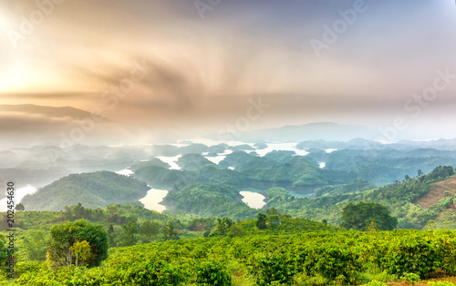 Ta Dung lake in the morning when the sun rises at the top of mountain shines fog into lake full of mist and small islands paradise. This is the reservoir for hydropower in Dac Nong, Vietnam.