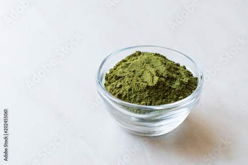 Green Matcha Tea Powder in Glass Bowl.