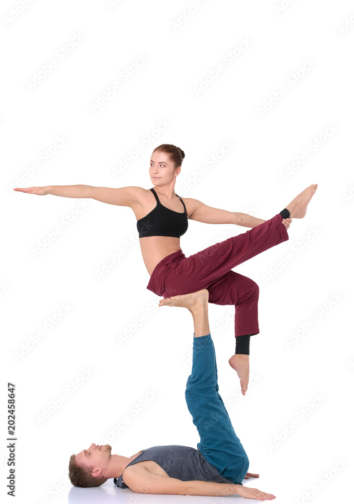 Young athletic couple practicing acroyoga. Balancing in pair Young athletic couple practicing acroyoga. Balancing in pair