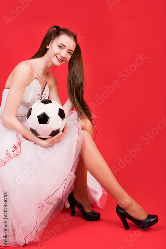 Girl in a dress of the bride with the ball for the game of football. © Sergey Potapov