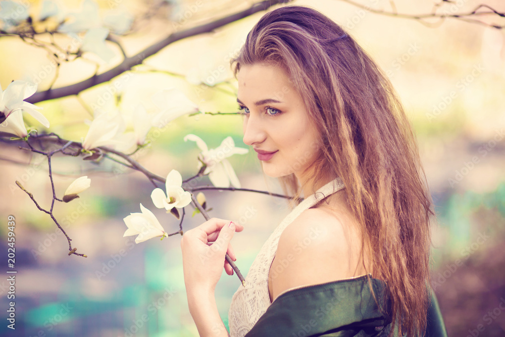 Naklejka premium girl posing in magnolia garden