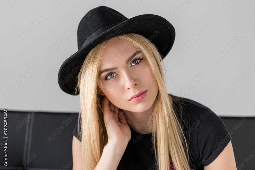 portrait of attractive woman in black hat looking at camera isolated on grey portrait of attractive woman in black hat looking at camera isolated on grey