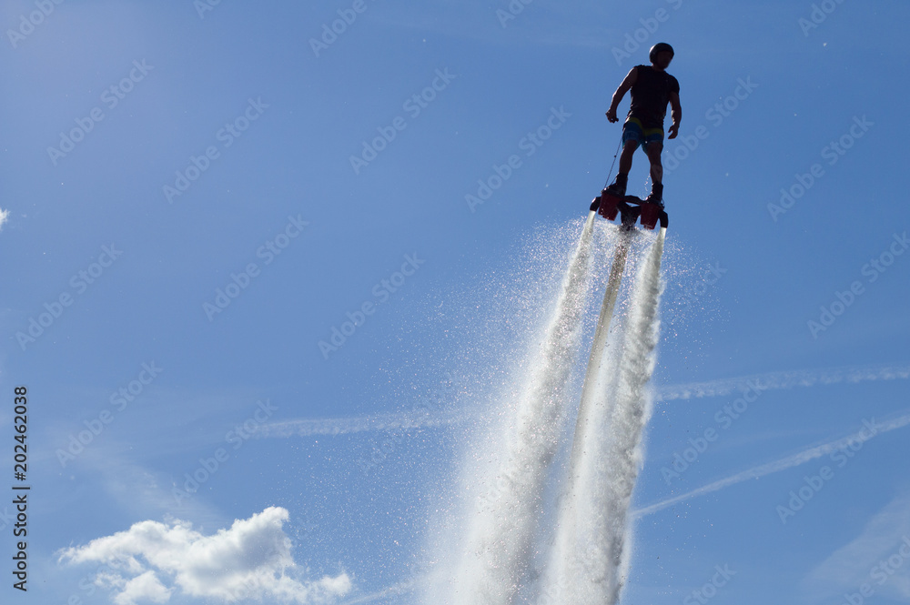 Flyboarding session in the aquamarine waters.. - obrazy, fototapety, plakaty 
