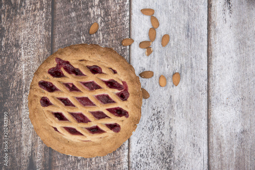 Blackberry and apple pie with almonds on a wooden background 