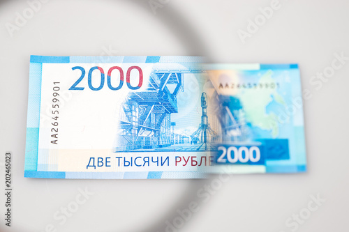 Two thousand roubles banknotes through a magnifying lens. Blurred background.