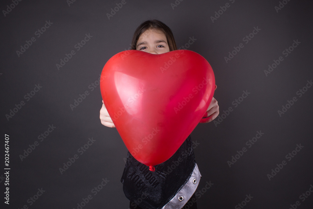 little girl with big balloon heart