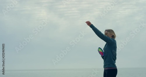 Young woman on beach throwing and catching ball photo