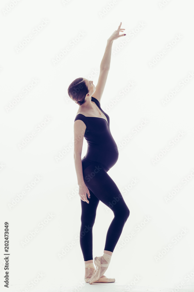 Young beautiful ballerina is posing in studio