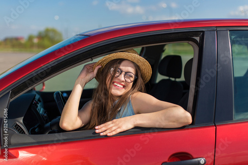 Young woman in car. Girl driving a car.  Smiling young woman sitting in red car   © Oleksandr Kozak