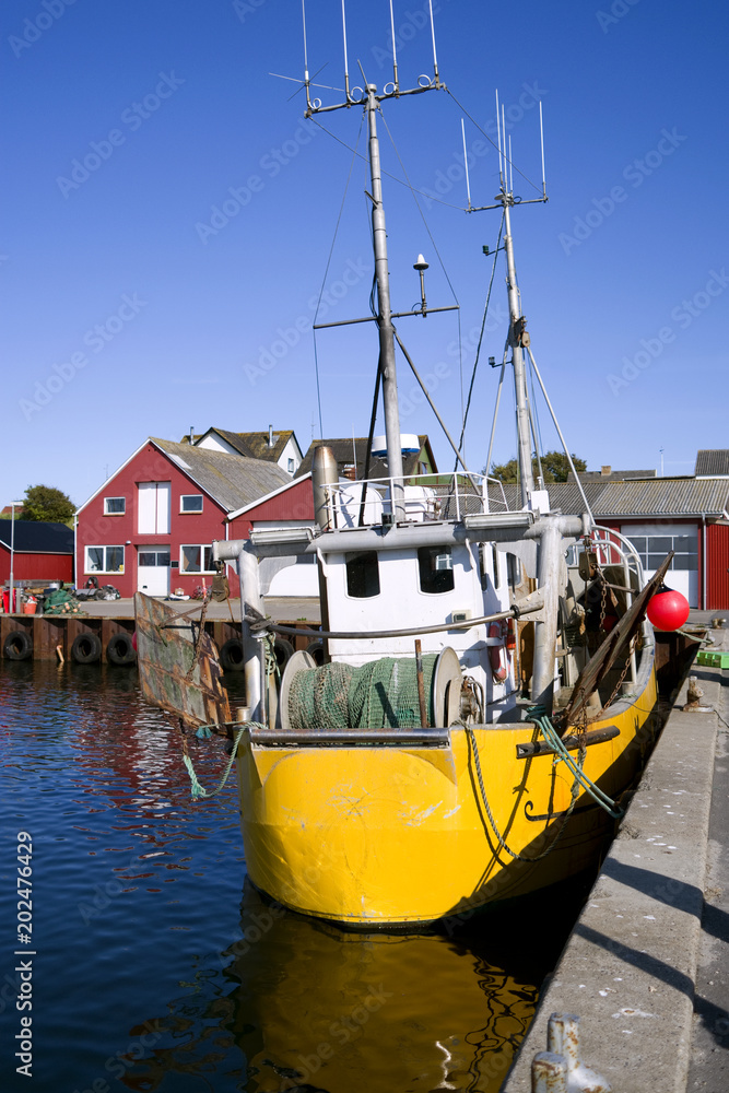 Φωτογραφία Laesoe / Denmark: Yellow fishing boat in the small fishing port of Vesteroe Havn