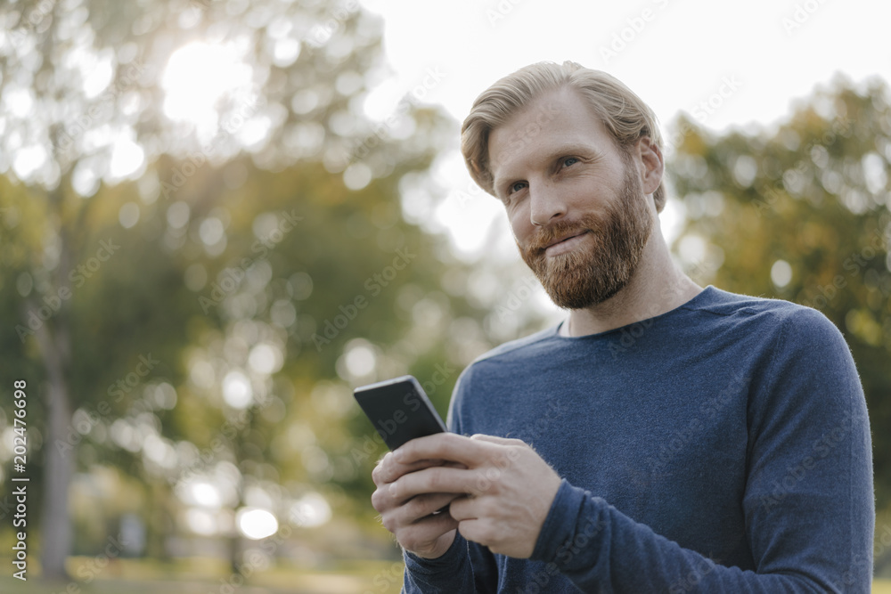 Portrait of man using cell phone in a park Portrait of man using cell phone in a park