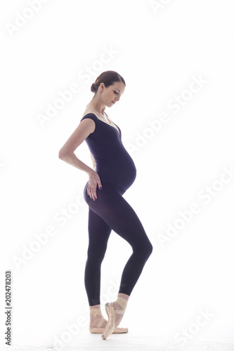 Young beautiful ballerina is posing in studio