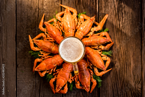 Boiled crayfish with beer on wooden background