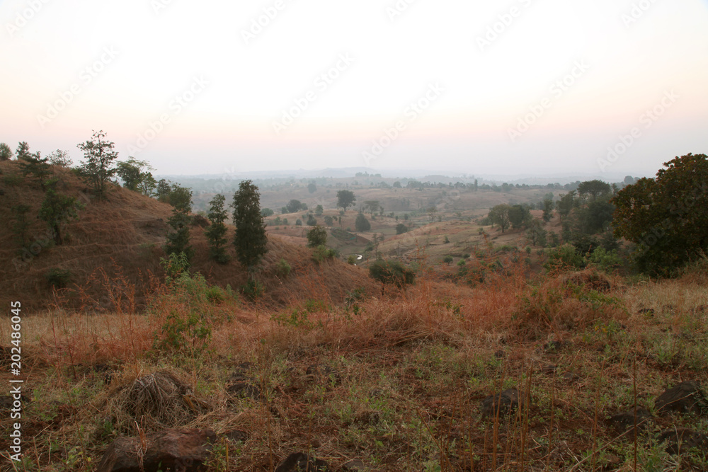 Foggy mountain valley at sunrise in the village in Nasik, Maharashtra, India Foggy mountain valley at sunrise in the village in Nasik, Maharashtra, India