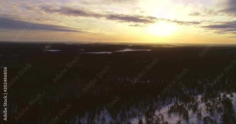 Sunrise in lapland, C4k aerial sideway view behind a tunturi fell and in arctic tundra wilderness, near luostotunturi fjeld, on a sunny winter morning dusk, Pyha-luosto national park, Finland Sunrise in lapland, C4k aerial sideway view behind a tunturi fell and in arctic tundra wilderness, near luostotunturi fjeld, on a sunny winter morning dusk, Pyha-luosto national park, Finland