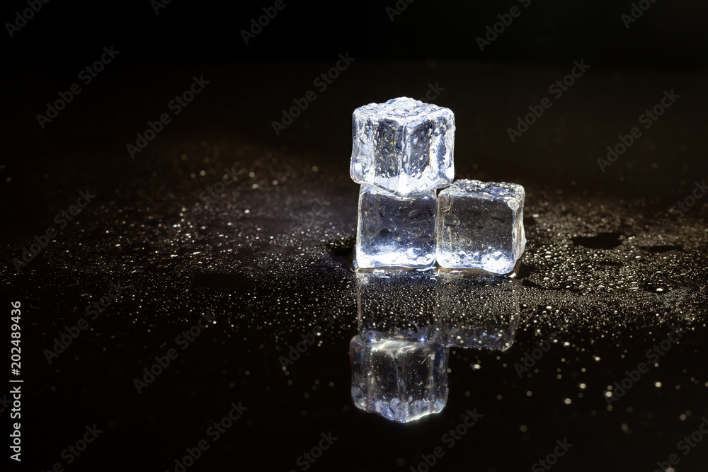 ice cubes reflection on black table background. ice cubes reflection on black table background.