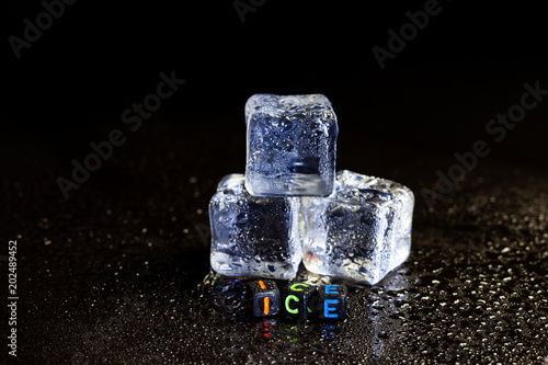 Fototapeta Naklejka Na Ścianę i Meble -  ice cubes reflection on black table background.
