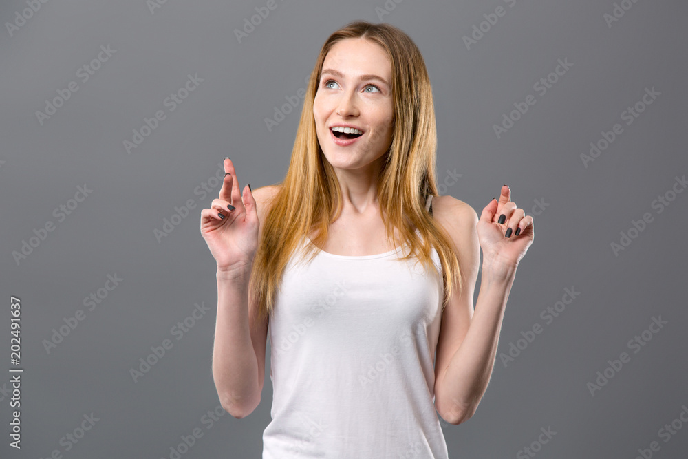 Wonderful emotions. Joyful delighted woman standing against grey background while feeling happy Wonderful emotions. Joyful delighted woman standing against grey background while feeling happy