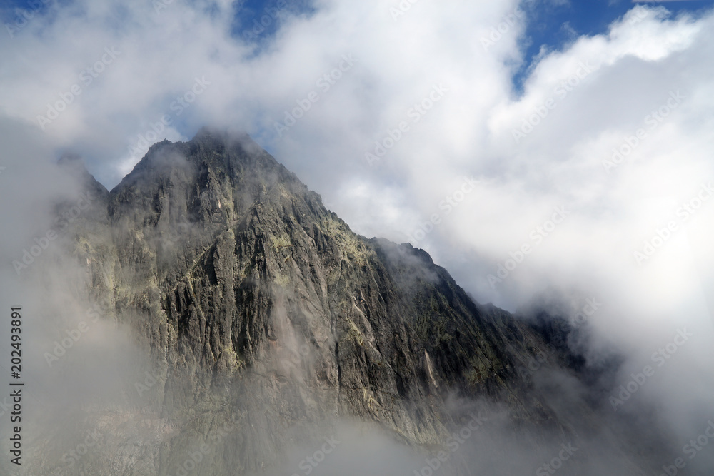Rocky mountain ridge in foggy clouds Rocky mountain ridge in foggy clouds