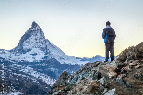 Junger Mann beim Bergsteigen in den Schweizer Alpen mit Matterhorn im Hintergrund © eyetronic