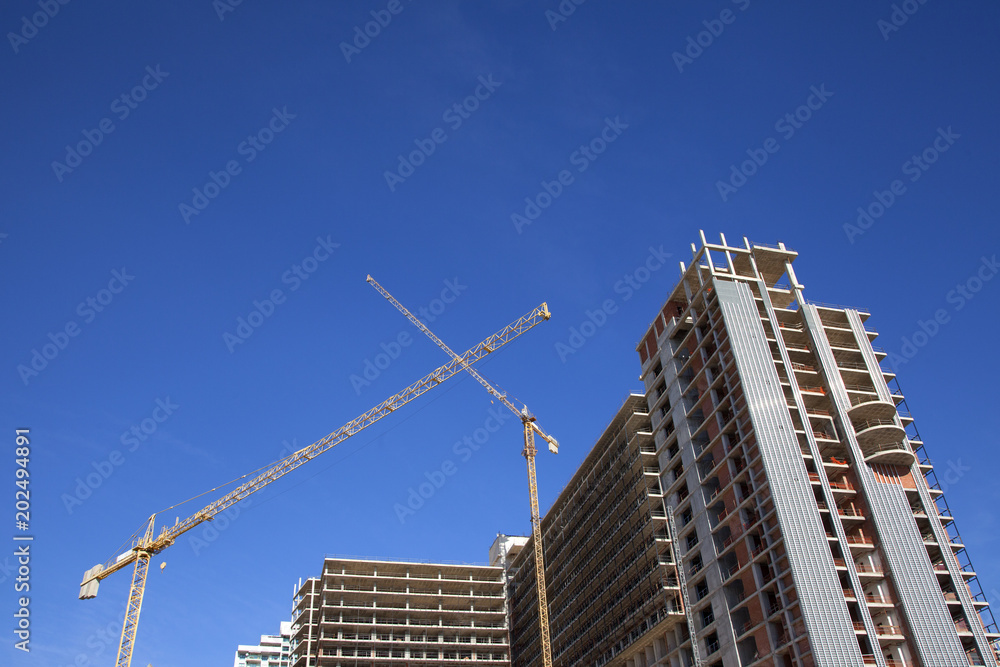 Construction of a high-rise building. Lifting cranes. Construction of a high-rise building. Lifting cranes.