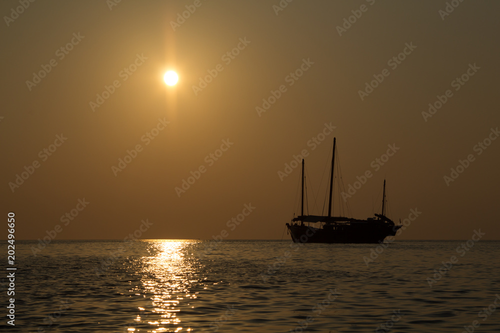 Wooden junk sail boat in the setting sails in the sunset of the Andaman Sea in Thailand Wooden junk sail boat in the setting sails in the sunset of the Andaman Sea in Thailand