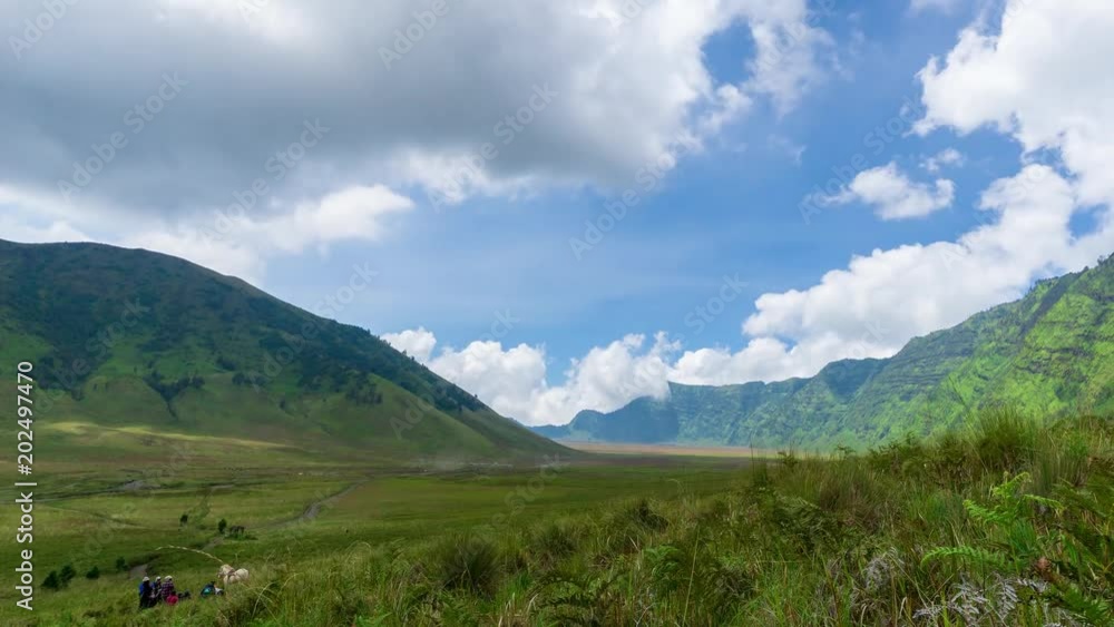 4K Time lapse of moving clouds over savannah of Bromo, a green hilly area looks green throughout the year. Zoom In. 4K Time lapse of moving clouds over savannah of Bromo, a green hilly area looks green throughout the year. Zoom In.