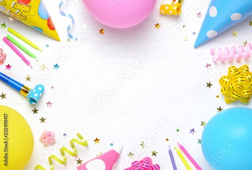 Birthday party caps, blowers, gifts, colorful balloons, serpentine and confetti on white background.