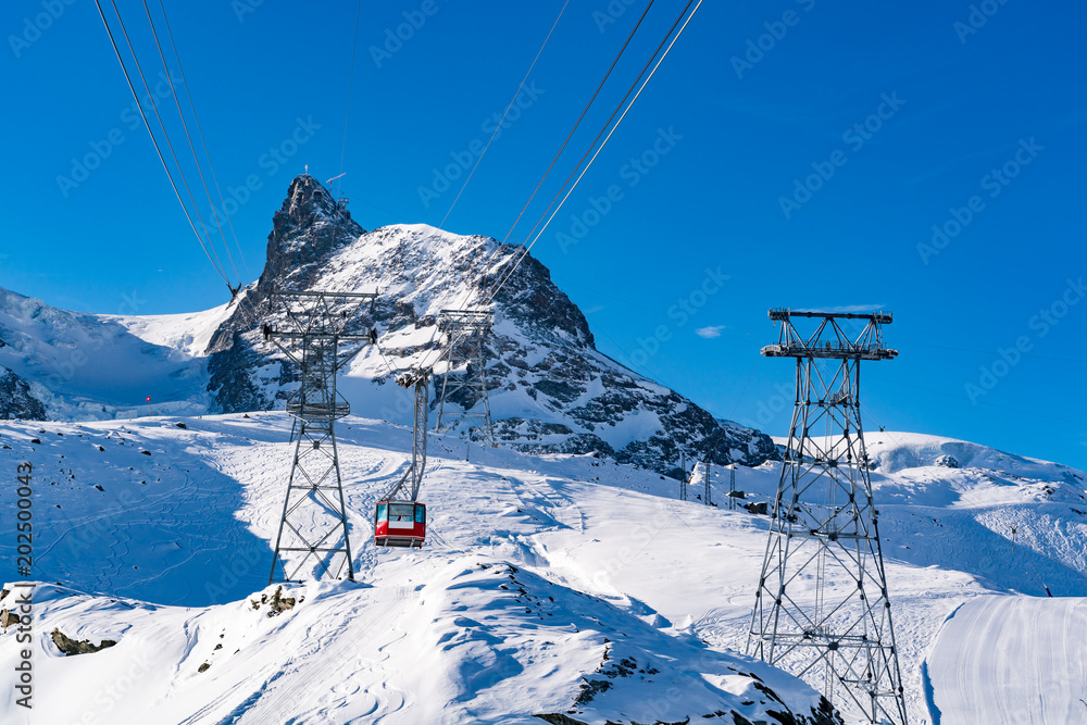 Beautiful view of Alps covered with snow and red cable car to Matterhorn peak
