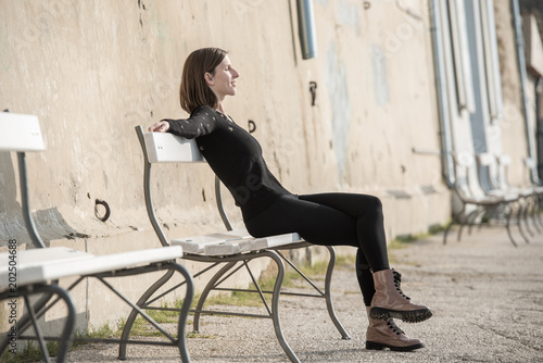 Slender woman relaxing on a rustic urban bench