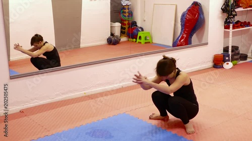 Young brunette woman doing yoga exercises in the gym.