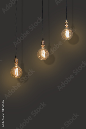 Three classic Edison lights bulb isolated on black background with space