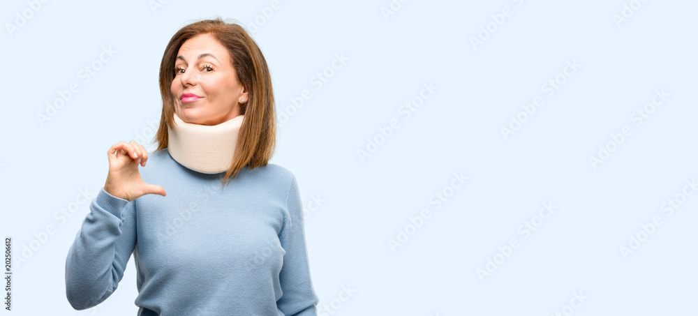 Injured woman wearing neck brace collar proud, excited and arrogant, pointing with victory face isolated blue background Injured woman wearing neck brace collar proud, excited and arrogant, pointing with victory face isolated blue background