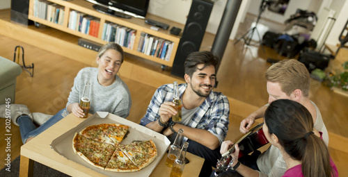 Young people having pizza party in the room