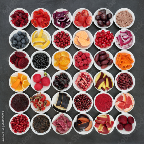  Healthy eating super food collection with fruit, vegetables, pulses and grains on slate background. Foods very high in antioxidants, anthocyanins and vitamins promoting good health. Top view.