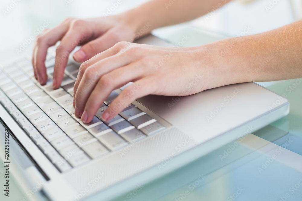 Close up of hands typing on a laptop Close up of hands typing on a laptop