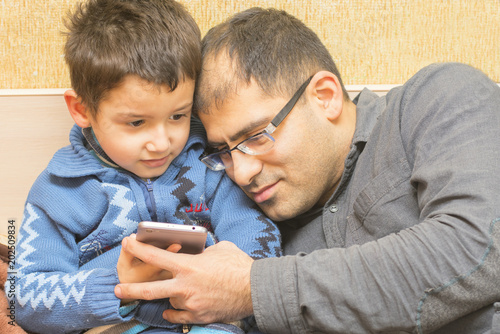 dad and son watching in the smartphone