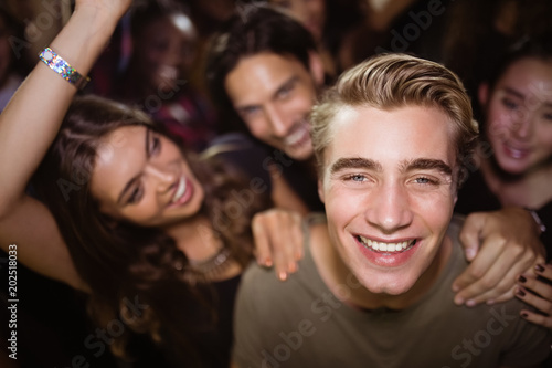 Portrait of happy man with friends at nightclub