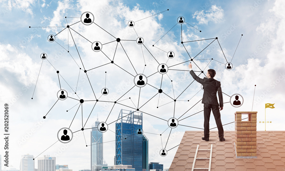 Businessman on house roof presenting networking and connection concept. Mixed media Businessman on house roof presenting networking and connection concept. Mixed media