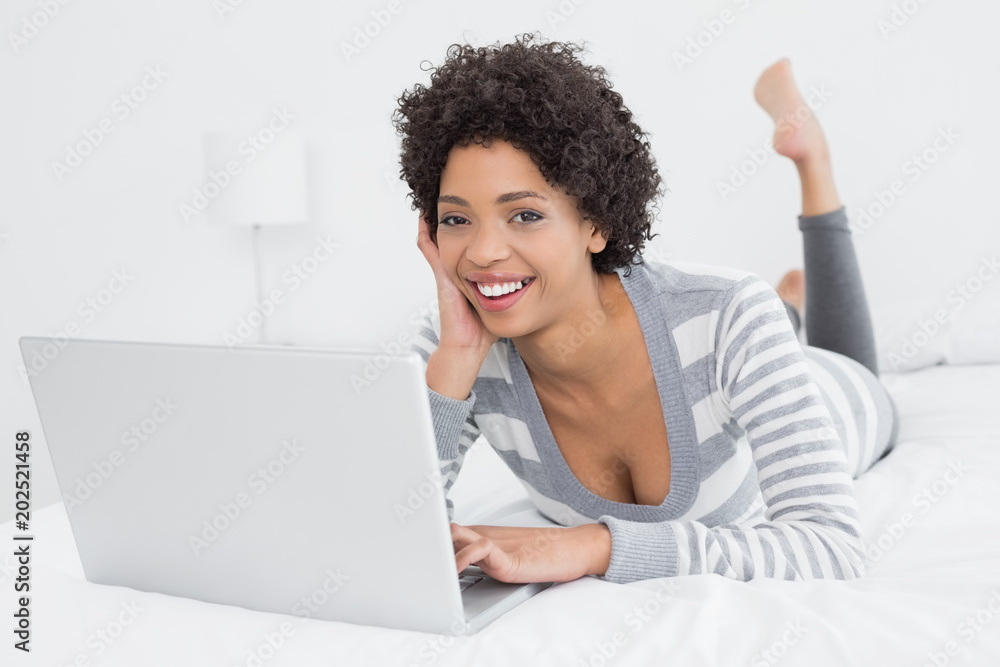 Pretty young woman using laptop in bed Pretty young woman using laptop in bed