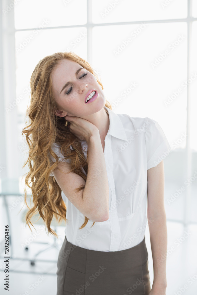 Elegant businesswoman with neck pain in office