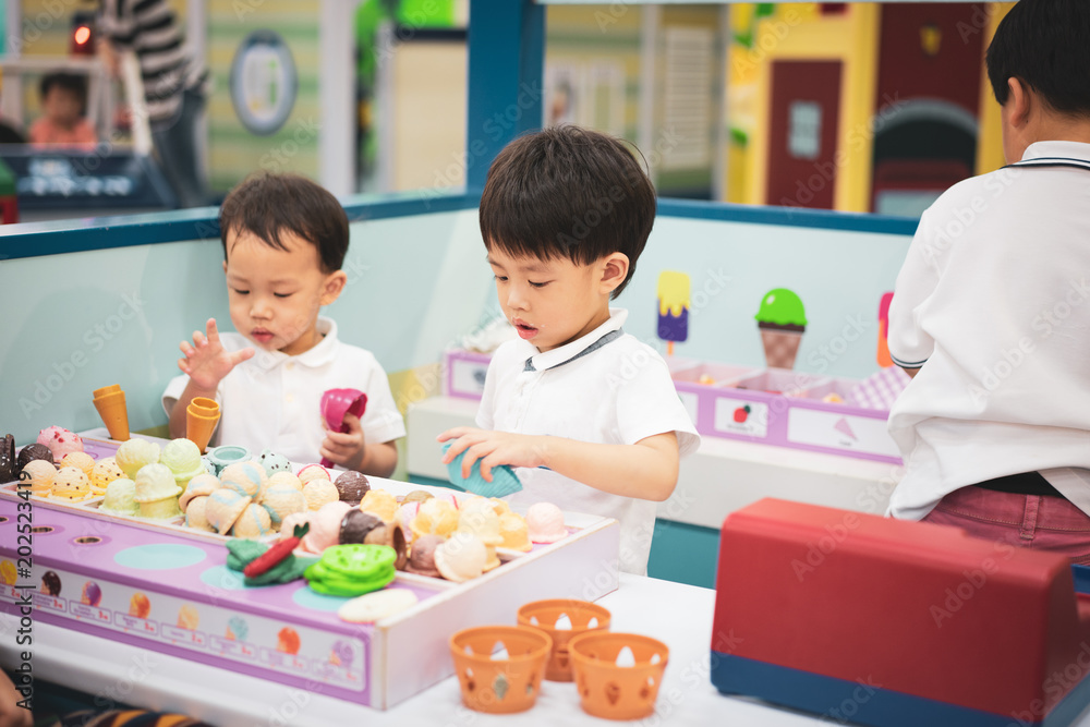 A little chef is playing a ice-cream toy. A little chef is playing a ice-cream toy.