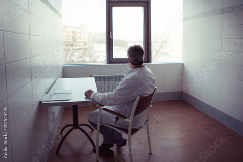 Doctor sits in the study on the chair photo