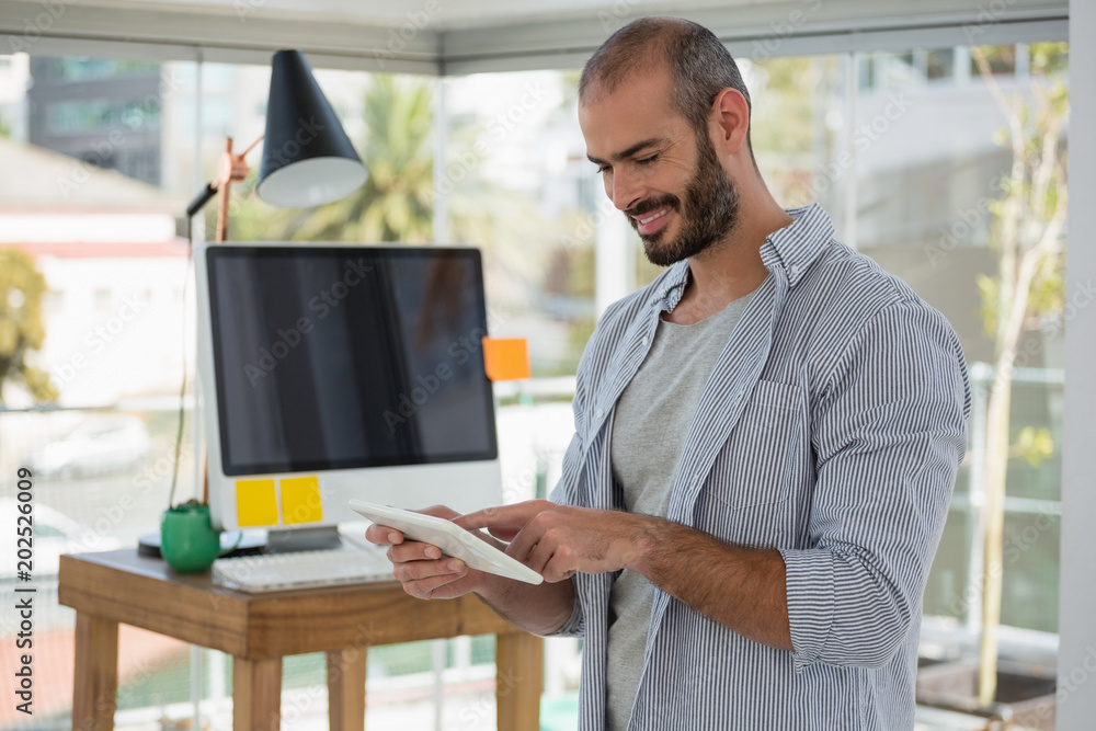 Smiling designer using digital tablet in office Smiling designer using digital tablet in office