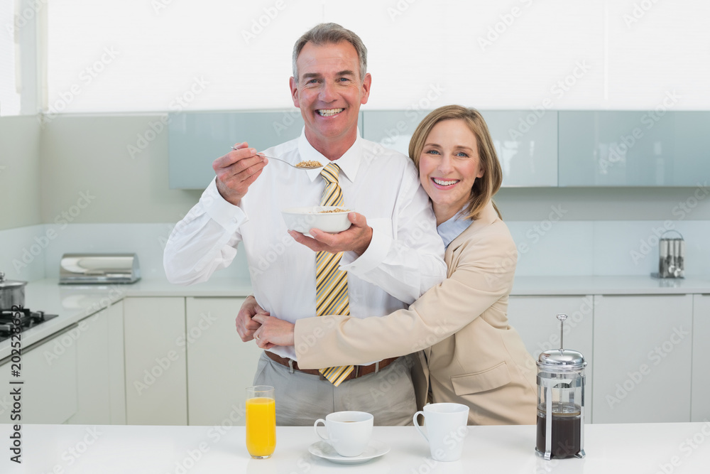 Woman embracing man while having breakfast in kitchen Woman embracing man while having breakfast in kitchen