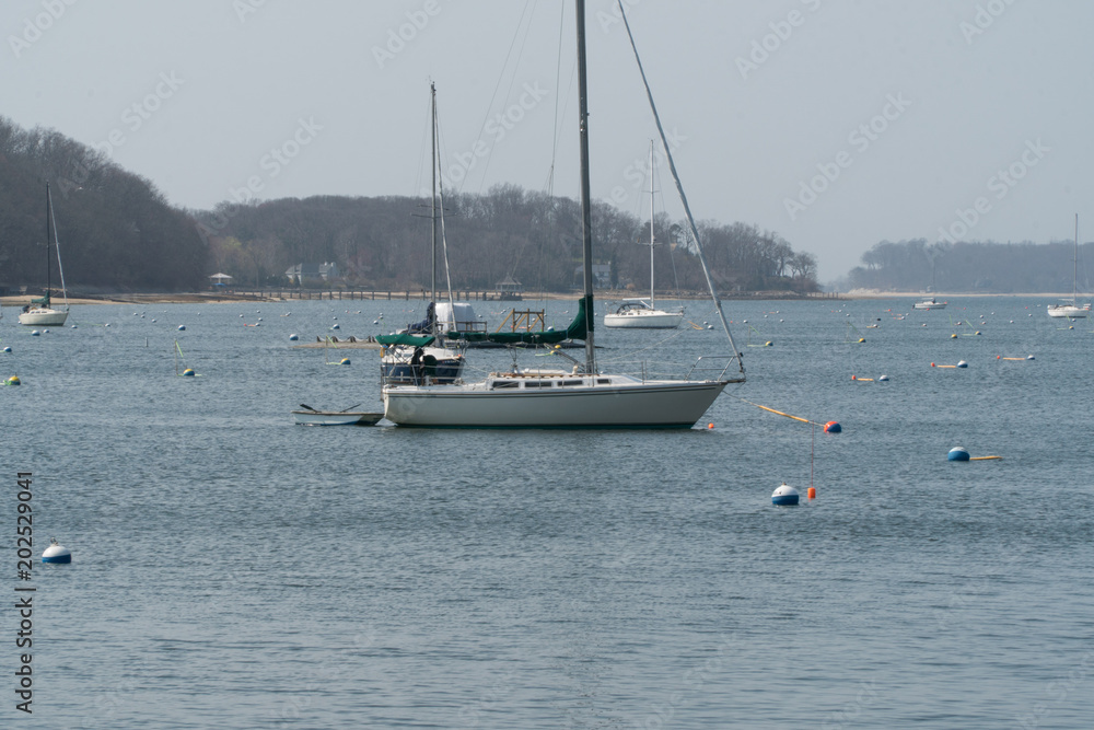 Sailboat mooring docks in coast town harbor water on a summer day Sailboat mooring docks in coast town harbor water on a summer day