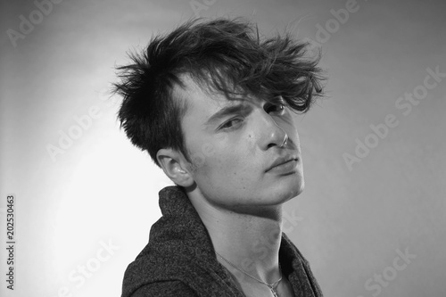 Man face close up. Beautiful young guy with long forelock, quiff. photo