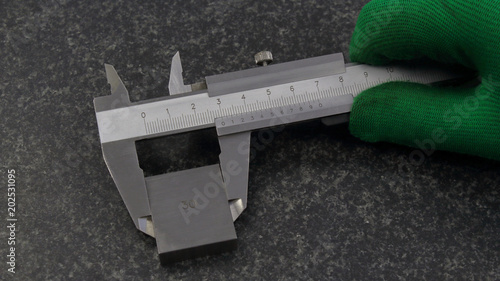 Calipers in hand, measuring rectangular parts