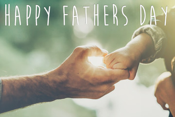 happy father's day text, greeting card concept. father and little son holding hands in sunlight in summer forest. Trust, care and parenting family concept. fathers day. road to life.