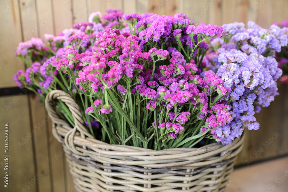 In a wicker basket variety of limonium sinuatum or statice salem flowers in pink, lilac, violet colors in the garden shop.